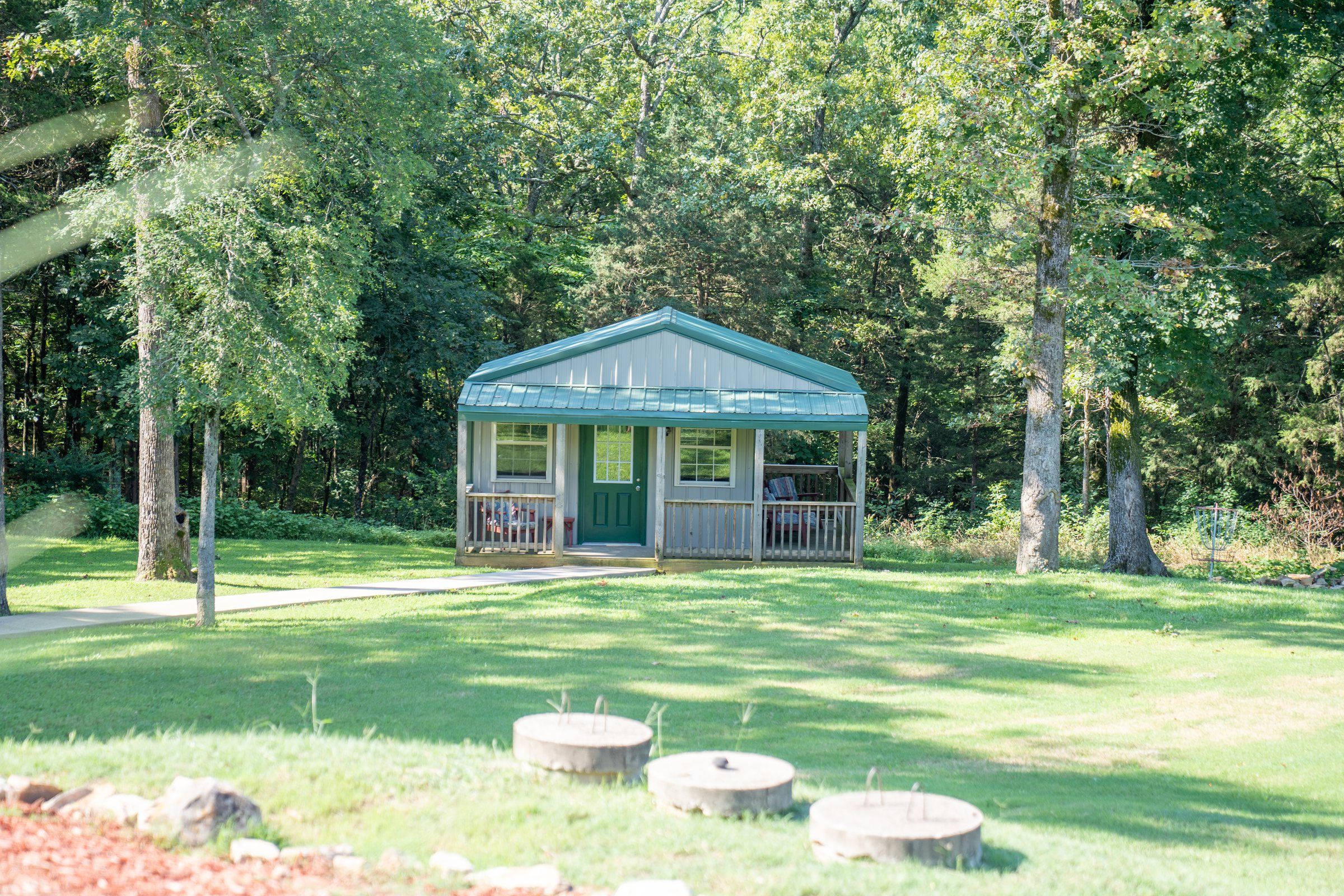 A green-roofed cabin among the oak trees on the Future Men campus