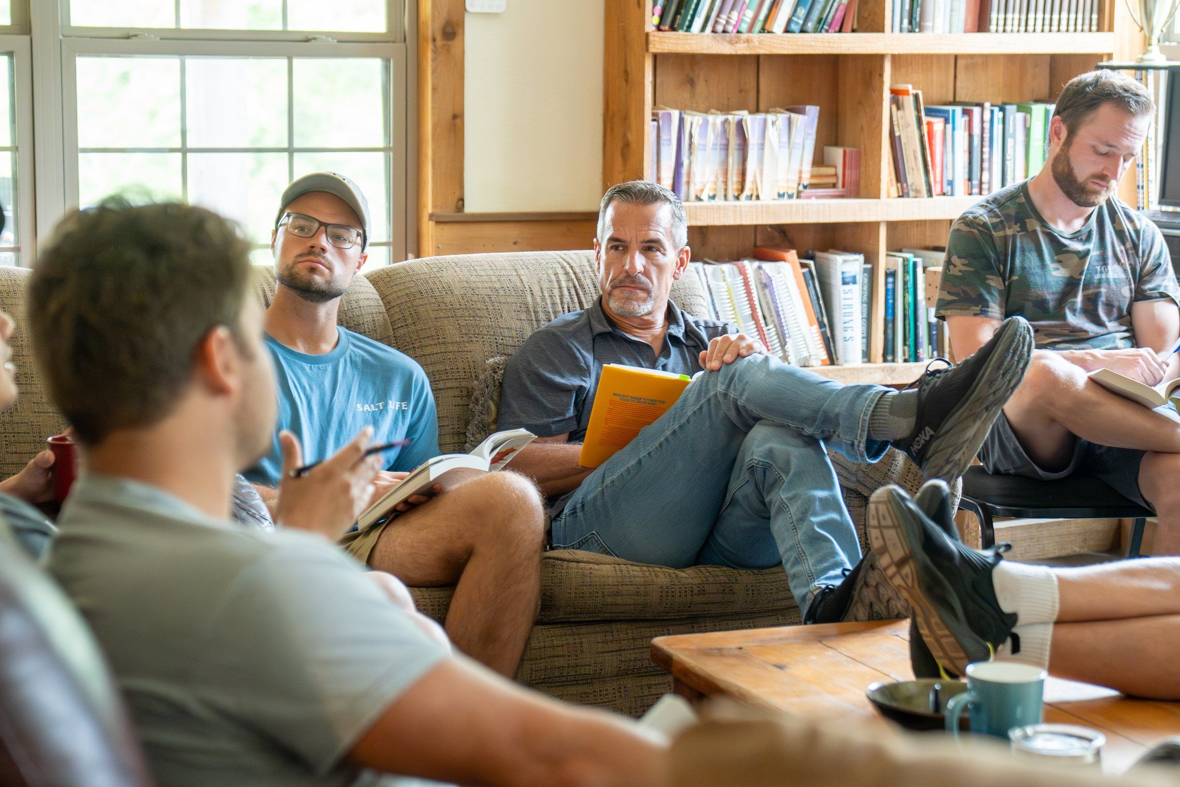 Future Men mentors and students in a Bible study in the lodge living room