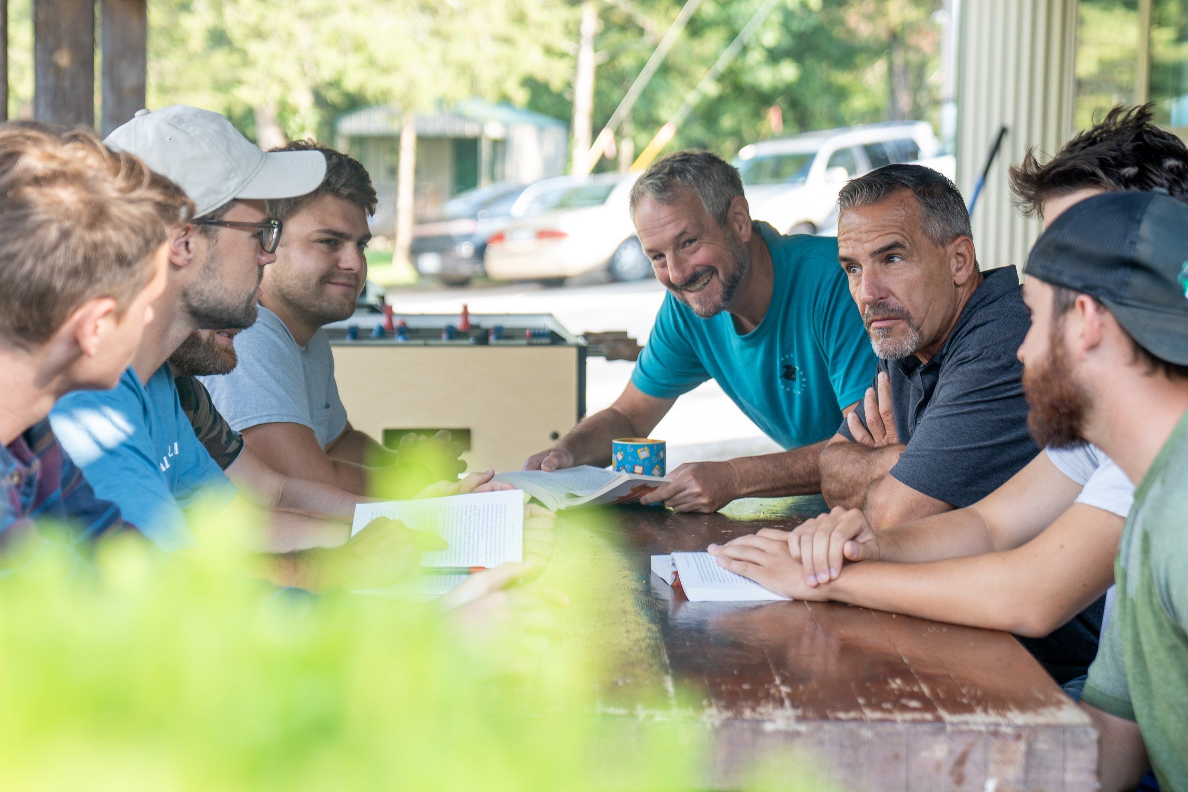 Future Men mentors and students talking around an outdoor table