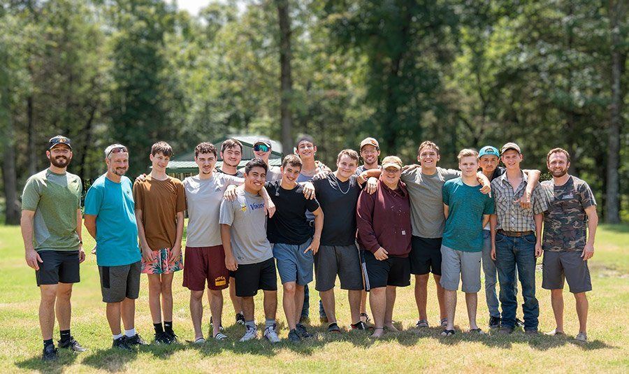 Future Men students and staff standing together on the campus lawn