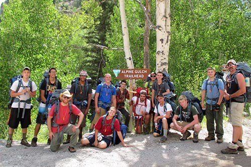 A Future Men hiking group with backpacks at a trailhead