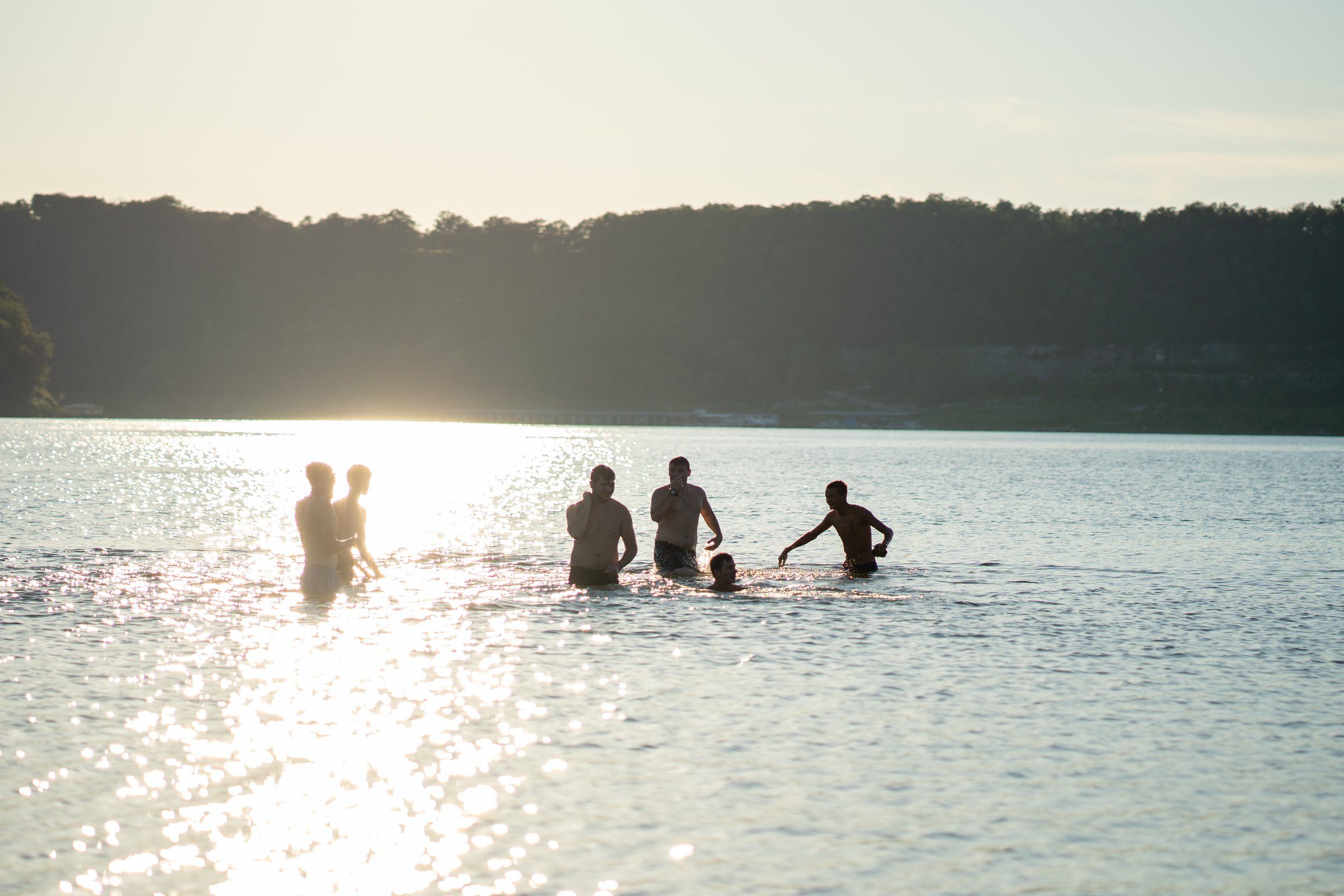 Future Men students wading into the lake in the late afternoon light
