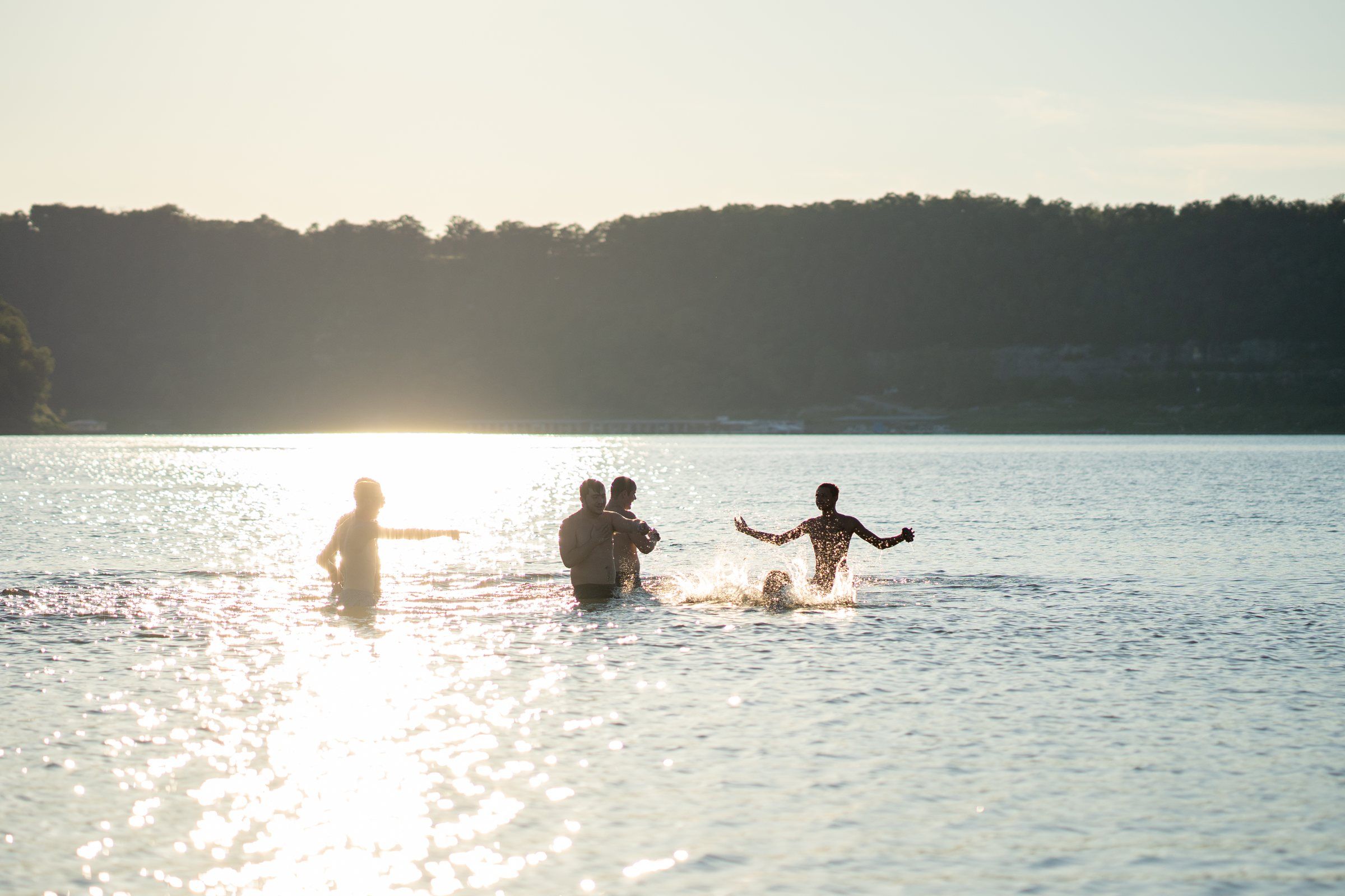Future Men students wading into the lake in the late afternoon sun