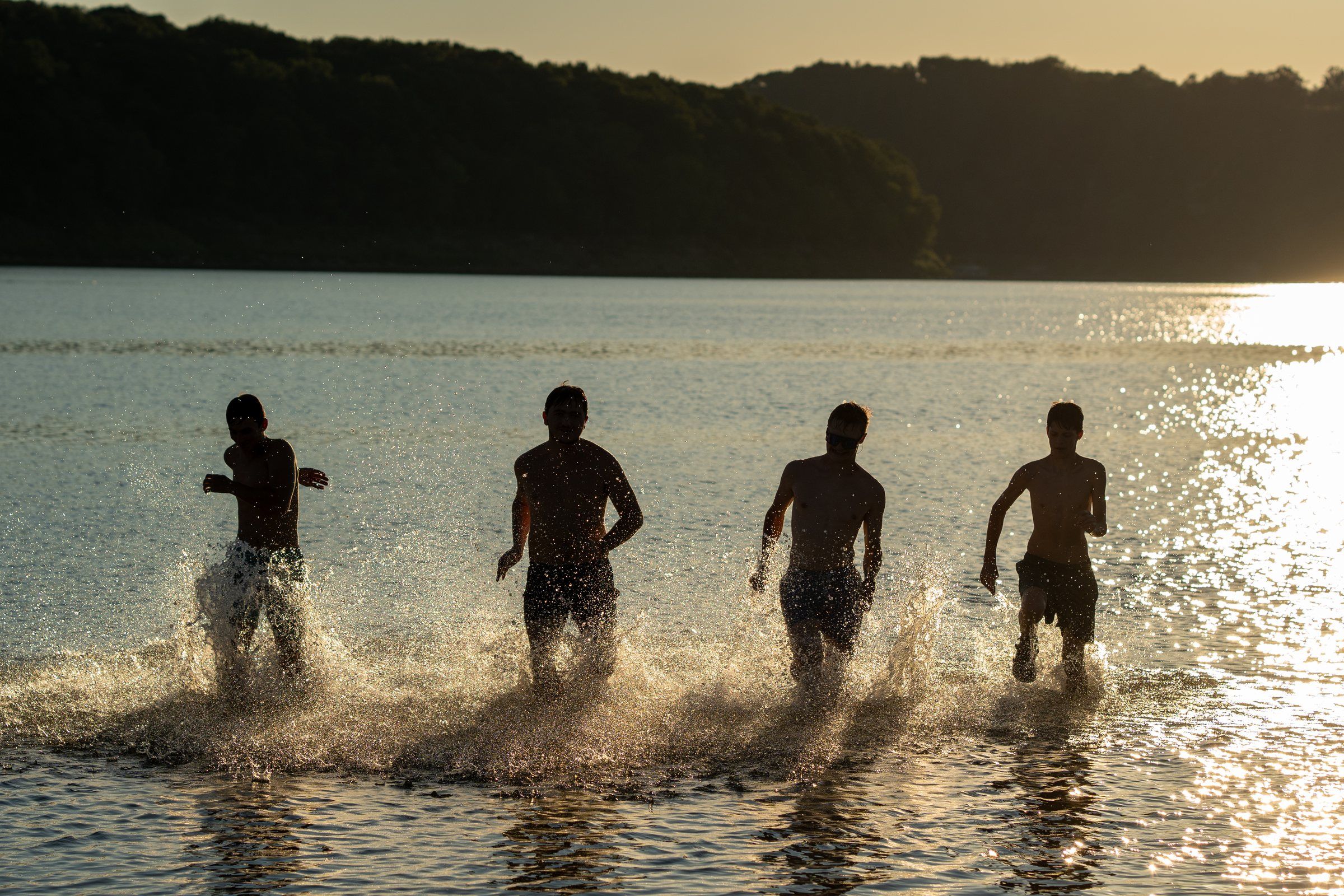 Future Men students running into the lake at sunset